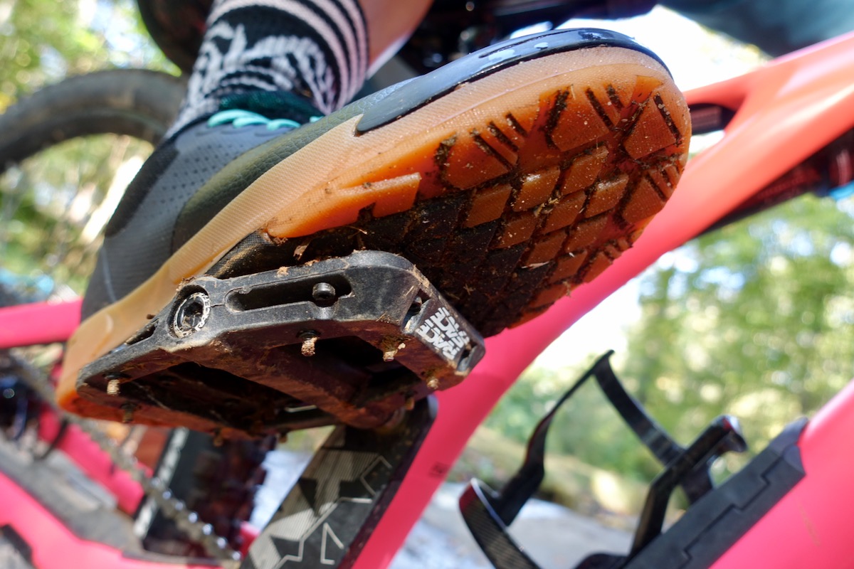 Pormenor de um pedal de bicicleta com um sapato, bem enquadrado.