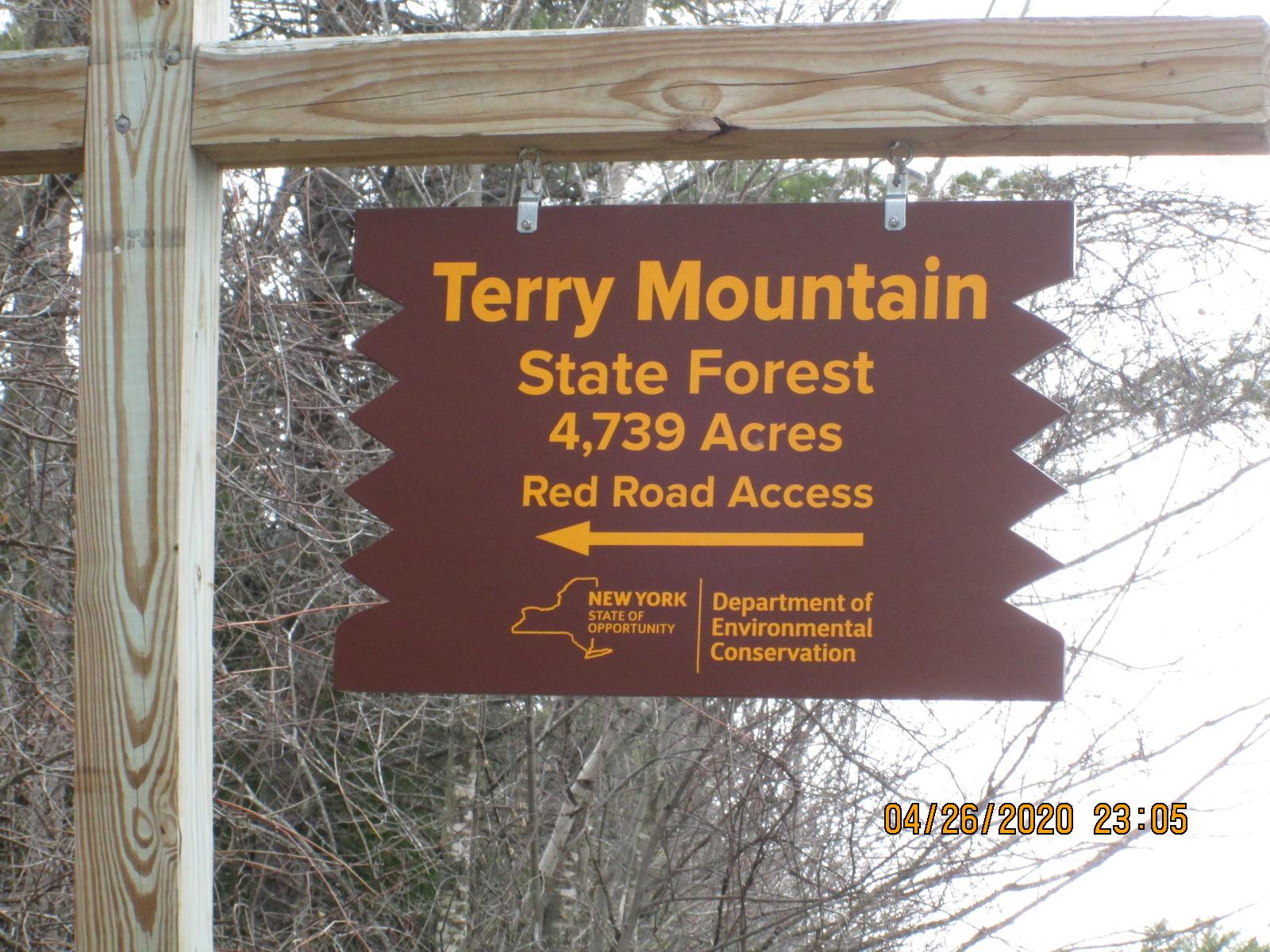 Sign for Terry Mountain State Forest, indicating it covers 4,739 acres and has access via Red Road. The sign is brown with yellow text and features the New York State Department of Environmental Conservation logo. Red Road mountain bike trail.
