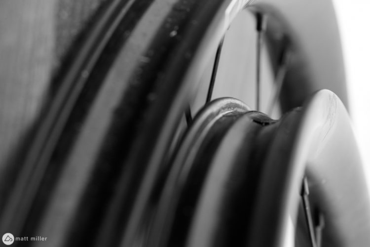 Close-up view of a black and white photograph featuring the edge of a two carbon mountain bike rims.