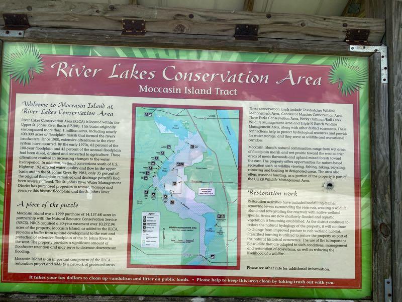 Sign at River Lakes Conservation Area, Moccasin Island Tract, providing information about the conservation area, its history, and restoration efforts. The sign features a map and text detailing the area