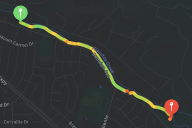Map image showing a route along Alamitos Creek, highlighted with a gradient from green to red to indicate traffic conditions. Key intersections include Mount Carmel Drive and Camden Avenue, with markers denoting starting and ending points. The background features a dark layout with residential streets. Alamitos Creek Trail mountain bike trail.