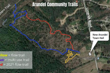 Map of Arundel Community Trails showcasing three types of trails: yellow for flow trails, blue for multi-use trails, and red for the 2021 flow trail. The map also indicates the location of the New Arundel Town Hall and features nearby roads and natural areas. Arundel Community Trails mountain bike trail.