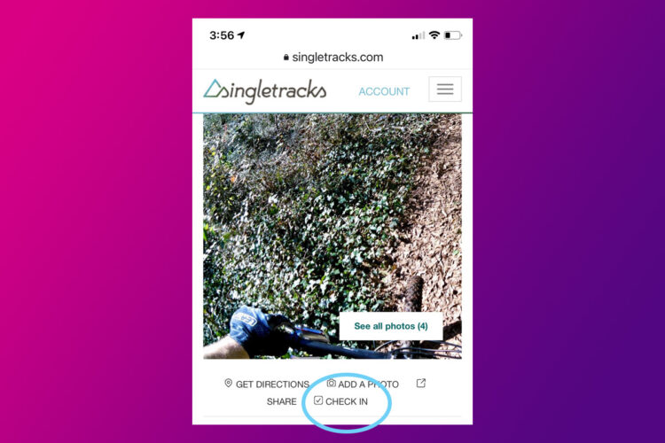 A mobile screen displaying the Singletracks website, featuring a mountain biking path with greenery and dirt. Options to "Get Directions," "Add a Photo," and "Check In" are visible at the bottom, along with the website logo and time at the top of the screen.