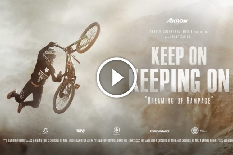 A mountain biker performing a mid-air trick against a dramatic, misty landscape, with the text "Keep On Keeping On" and "Dreaming of Rampage" prominently displayed. The image includes production credits for Akron and Zenith Adventure Media.