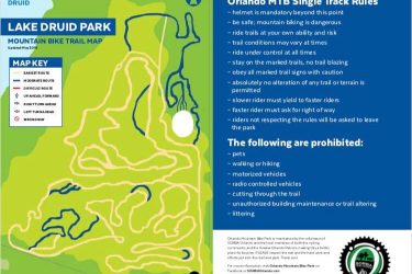A colorful map of Lake Druid Park featuring mountain biking trails. The map includes a key for different trail difficulties (easiest, moderate, difficult) and specific rutas. Safety rules and prohibited activities for mountain biking are listed on the right side, emphasizing the importance of wearing helmets, staying on marked trails, and respecting park regulations. The map is updated as of May 2018. Orlando Mountain Bike Park mountain bike trail.