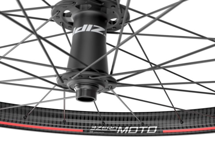 Close-up view of a bicycle wheel hub and spokes, showcasing a carbon fiber rim with a black and red design. The image highlights the intricate web of spokes connected to the hub, emphasizing the wheel's structure and material details.