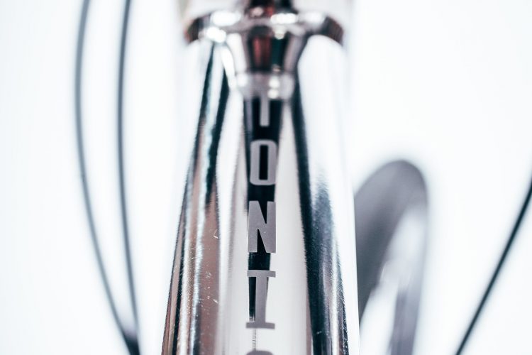 Close-up image of a bicycle's frame with a shiny, reflective surface. The photo highlights the brand name "VONTIC" printed vertically along the frame. The background is simple and blurred, emphasizing the detail of the bike's components.