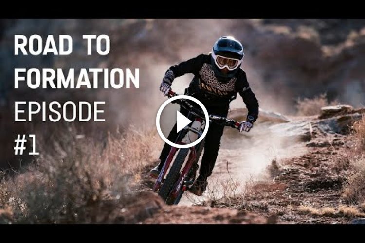 A mountain biker in a helmet and protective gear rides confidently along a rocky trail, kicking up dust in the background. The image features text that reads "Road to Formation Episode #1."