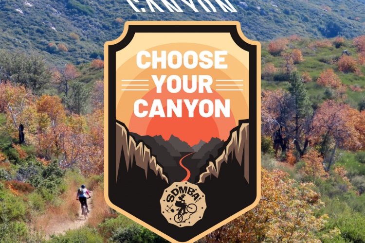 A scenic view of a canyon landscape featuring vibrant greenery and autumn colors, with a mountain biker riding along a dirt trail. A graphic overlay features a badge that reads "Choose Your Canyon," highlighting the outdoor adventure theme. The background includes the word "CANYON" prominently displayed on the hillside.