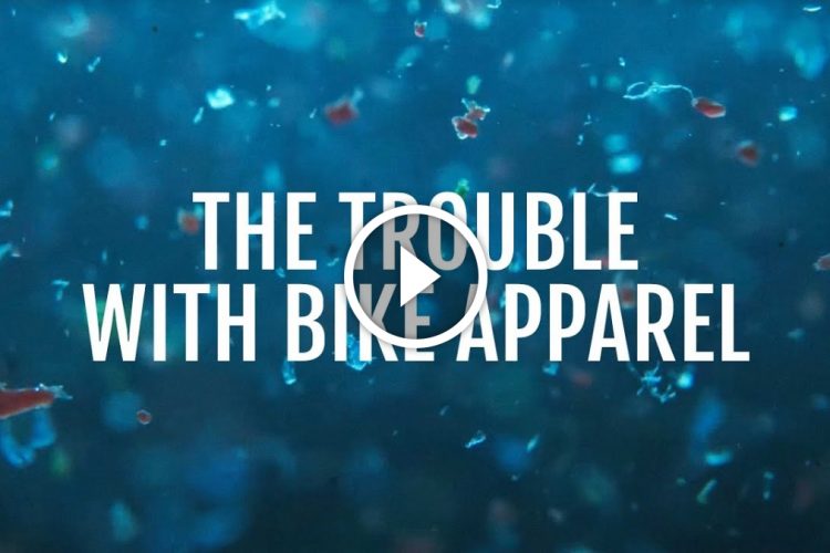 A textured blue background with floating particles and the text overlay "The Trouble with Bike Apparel," accompanied by a play button icon in the center.
