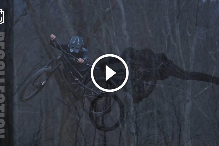 A cyclist in a helmet performs a mid-air trick on a mountain bike against a wooded background, with a dark overlay that enhances the dynamic movement of the scene. The image includes a logo and a play button, suggesting it is part of a video or multimedia presentation.