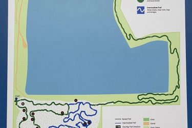 Map of the Xcel Energy Mountain Bike Park, featuring trails for different skill levels. The map shows the layout of the park with designated areas for the easiest and intermediate trails, a skills feature area, a pump course, and parking locations. Key elements include a starting point and an endpoint, along with symbols indicating trails' surfaces and directions. Xcel Energy Mountain Bike Park mountain bike trail.
