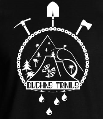 A black graphic design featuring the text "Duchas Trails" at the center, surrounded by mountain imagery, palm trees, and various tools including a pickaxe, shovel, and axe. The design also includes decorative elements like a circular border and teardrop shapes at the bottom. DuchasTrails mountain bike trail.