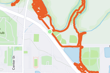 Map displaying a route highlighted in orange against a green landscape, with streets and bodies of water indicated in blue and light green. The location is marked by a green circle. ESU Trail mountain bike trail.