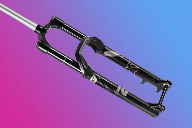 Image of a black bicycle front fork with a sleek design, featuring dual suspension tubes and visible branding. The background is a gradient transitioning from pink to blue.