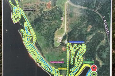 Map of a recreational area displaying various hiking and biking trails, including Muskrat Maze (4 miles), Scorpion Strut (0.9 miles), and Black Snake Boogie (2 miles). The trails are outlined in bright yellow on a green and blue background, indicating different paths. Additional details include parking locations and trail connectors. Lake Ponca Trails mountain bike trail.