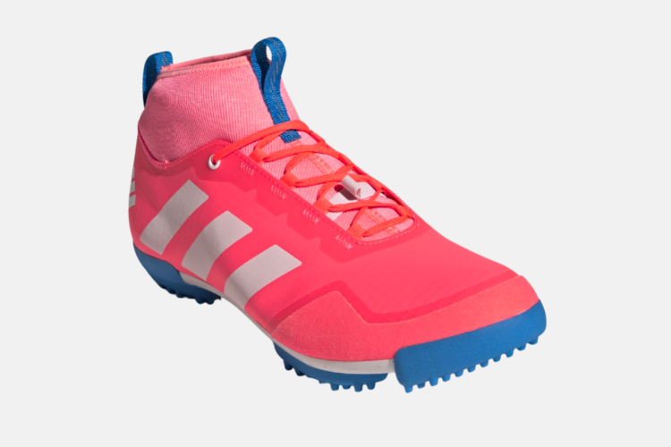 A vibrant pink athletic shoe with white stripes and blue accents, featuring a sock-like upper and lace closure, designed for performance and comfort.