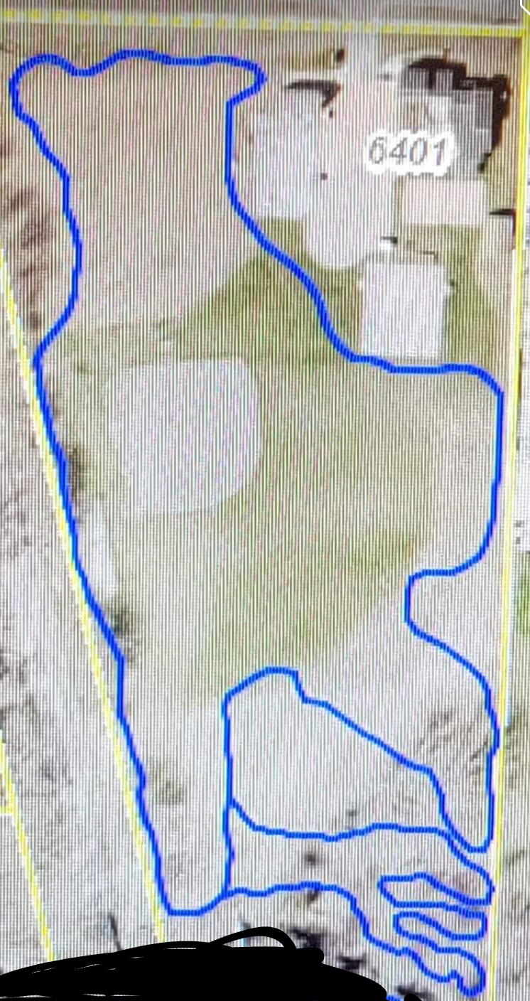 A map indicating property boundaries, featuring a blue outline that traces an irregular shape on a light background, with a few structures and roads visible within the area. Campus Life Single Track mountain bike trail.