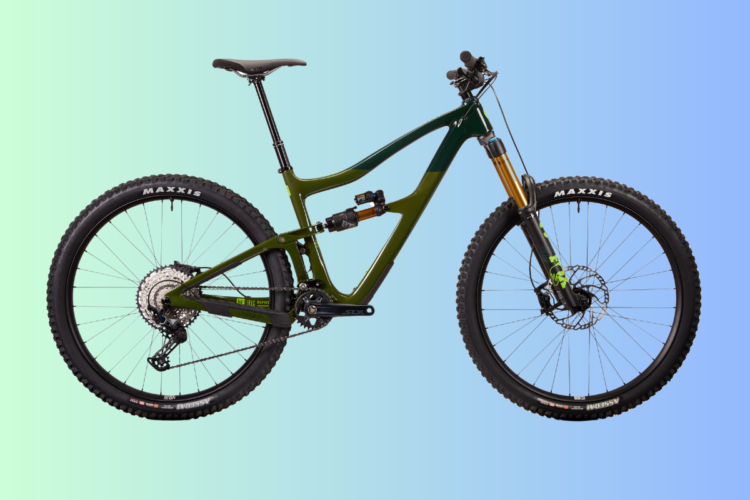A modern mountain bike with a sleek green and black frame, featuring robust tires and a shiny suspension fork. The bike is shown against a gradient background that transitions from light blue to green.