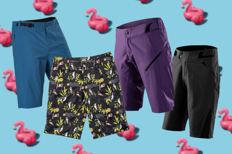 Four pairs of shorts in various styles and colors are displayed against a light blue background adorned with pink flamingo illustrations. The shorts include a blue pair, a black pair with a colorful tropical pattern featuring flamingos and other flora, a purple pair with a sleek design, and a black pair with a modern cut.