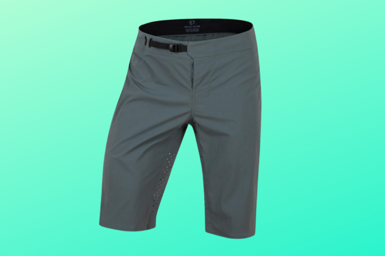 A pair of gray cycling shorts with a sleek design, featuring an adjustable waistband and perforated detailing on the side for breathability, set against a light green background.