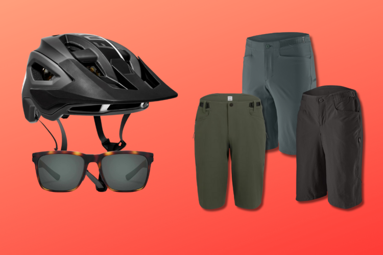 Alt text: A black bicycle helmet, stylish sunglasses, and three pairs of shorts in different colors (green, gray, and black) featured against a bright orange background.