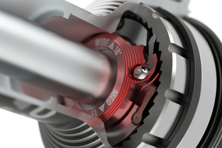 Close-up view of a precision-engineered mechanical component featuring a red adjustment dial and intricate metal parts, highlighting the internal mechanics of a device. The cylindrical structure and gears suggest functionality related to machinery or automotive systems.