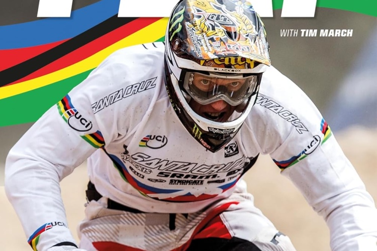 Book cover featuring an action shot of a mountain biker wearing a helmet and protective gear. The title "STEVE PEAT" is prominently displayed along with "FORGED BY SPEED" and the subtitle "THE MAKING OF A MOUNTAIN BIKE WORLD CHAMPION." A colorful background incorporates the UCI rainbow stripes, emphasizing the sport's heritage.