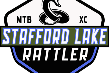 Logo design for the Stafford Lake Rattler event, featuring a stylized snake coiled and ready to strike. The logo includes the text "MTB XC" at the top, "STAFFORD LAKE" in bold green letters, and the word "RATTLER" in prominent white letters on a black background. The overall shape is a shield with blue accents.