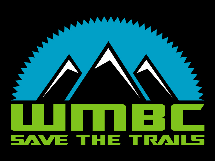 Graphic logo featuring three stylized mountain peaks in shades of blue, with the letters "WMBC" prominently displayed in bold green text below. The slogan "SAVE THE TRAILS" is positioned underneath the acronym, emphasizing a commitment to trail preservation. The background is black, enhancing the visibility of the vibrant colors.