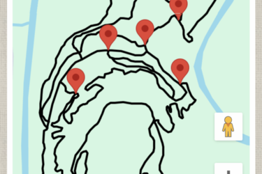 Map showing a trail system with winding paths and several marked locations indicated by red pins. The map features a river running along one edge and is presented in both map and satellite views. A person icon is visible on the map, and navigation options are available at the bottom. Eagle Rock Mountain Bike Trail mountain bike trail.