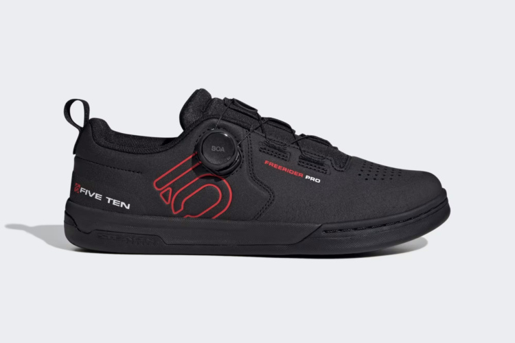 Alt text: A black Five Ten Freerider Pro cycling shoe featuring a BOA closure system and red detailing, positioned against a light gray background. The shoe is designed for optimal performance and grip in biking activities.