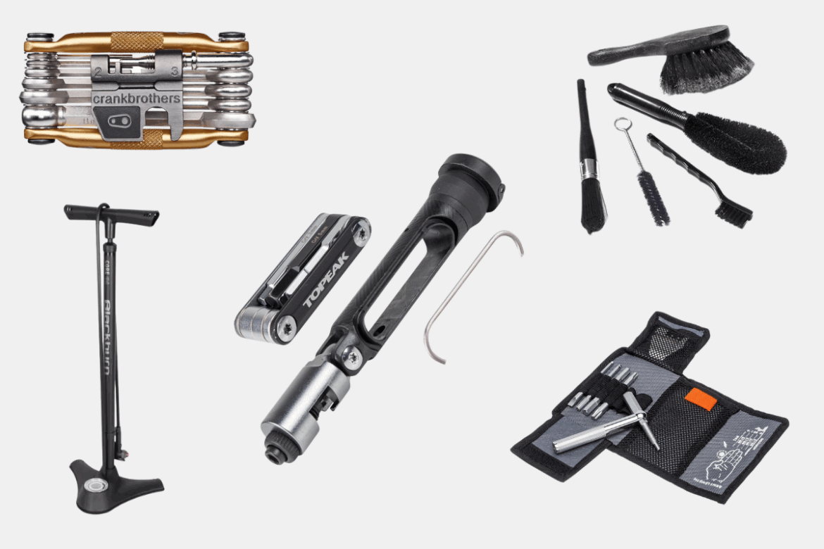 A collection of bicycle maintenance tools, including a multi-tool, tire pump, and various cleaning brushes, arranged neatly. The tools showcase brands like Crankbrothers and Topeak, highlighting their compact design and functionality for cyclists.
