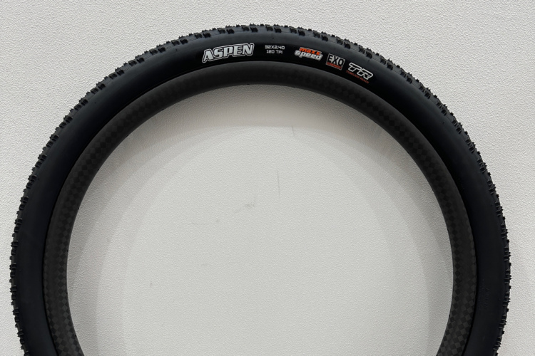 A close-up view of a mountain bike tire mounted on a white background. The tire is labeled "ASPEN" and has specifications including "32x40" and "120 TPI." The tread pattern is designed for grip and performance on various terrains.