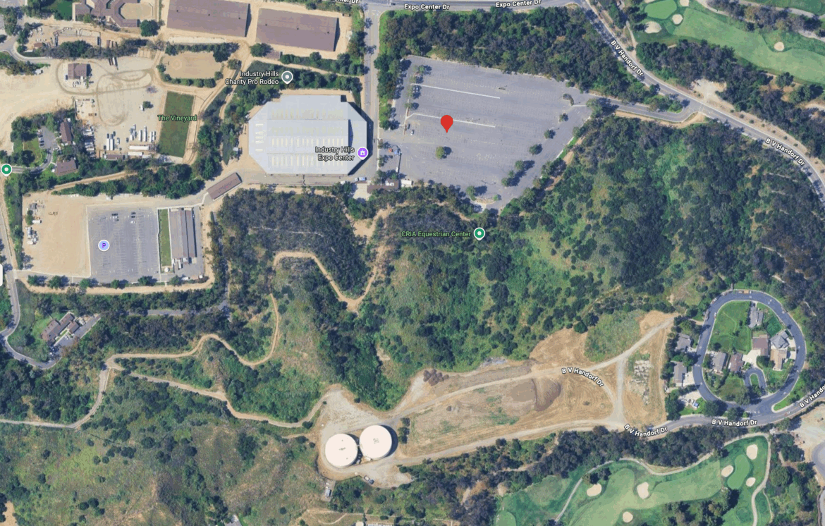 Aerial view of a landscape featuring parking lots, buildings, and green areas. The image shows the Industry Hills Expo Center and the CRIA Equestrian Center, along with meandering paths and landscaping typical of a recreational area.