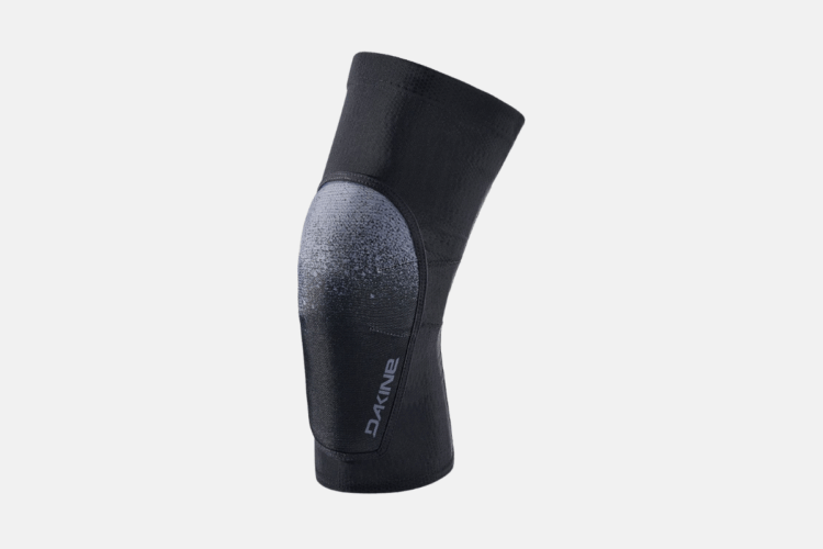 A black knee pad with a textured design and a gradient pattern featuring a lighter shade near the top. The product logo is displayed on the side, and the overall design emphasizes functionality for sports or outdoor activities.