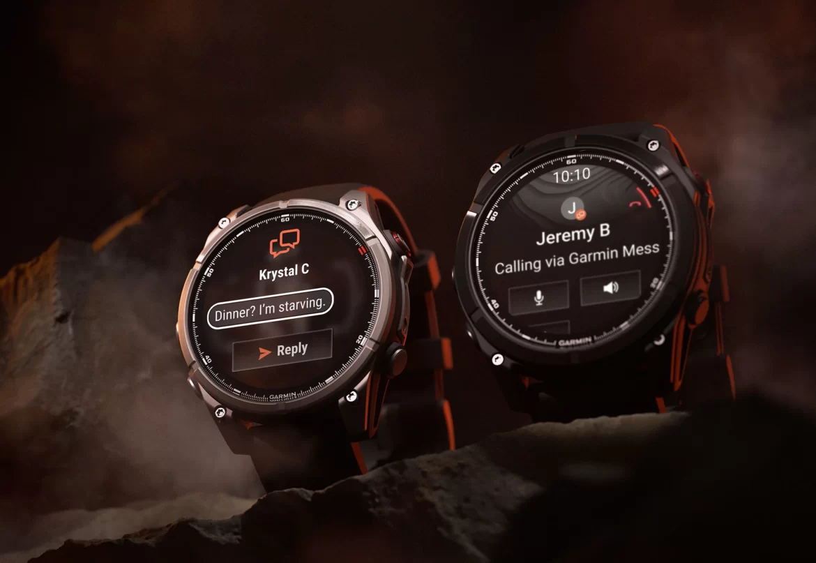 Two Garmin smartwatches are displayed against a dark, smoky background. The left watch shows a message notification from "Krystal C" with the text "Dinner? I'm starving." and a reply button. The right watch indicates an incoming call from "Jeremy B" with options for voice and audio interaction. The watches have rugged designs, emphasizing their outdoor capabilities.
