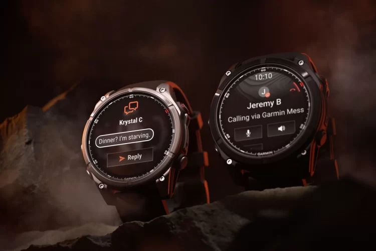 Two Garmin smartwatches are displayed against a dark, smoky background. The left watch shows a message notification from "Krystal C" with the text "Dinner? I'm starving." and a reply button. The right watch indicates an incoming call from "Jeremy B" with options for voice and audio interaction. The watches have rugged designs, emphasizing their outdoor capabilities.