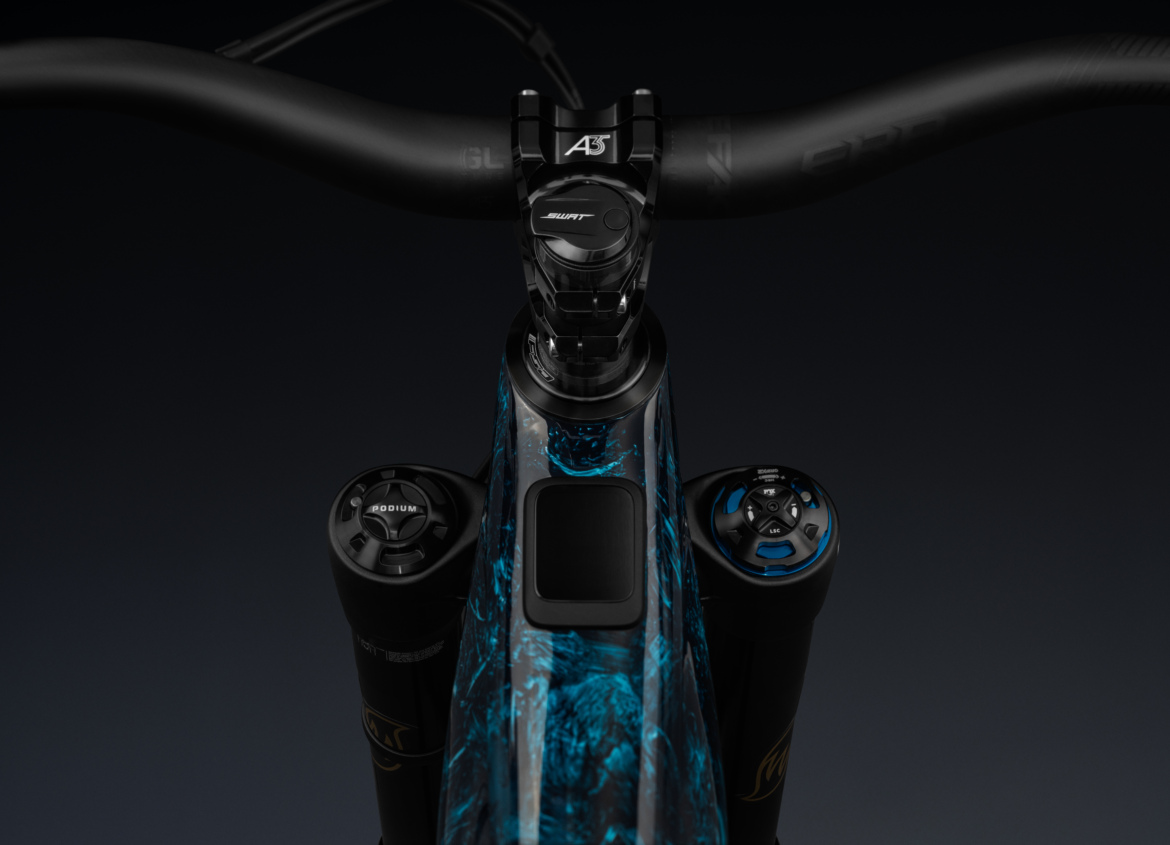 Alt text: Close-up view of a mountain bike's handlebar, stem, and top tube featuring a blue and black marbled design, with adjustable suspension controls on each side.