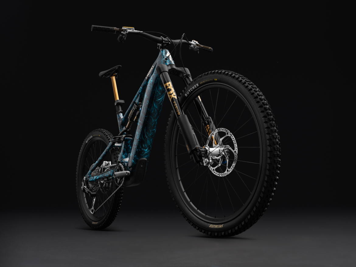 A stylish mountain bike with a striking blue and black design, featuring a lightweight frame, thick tires, and high-quality components, all presented against a dark background to highlight its details.