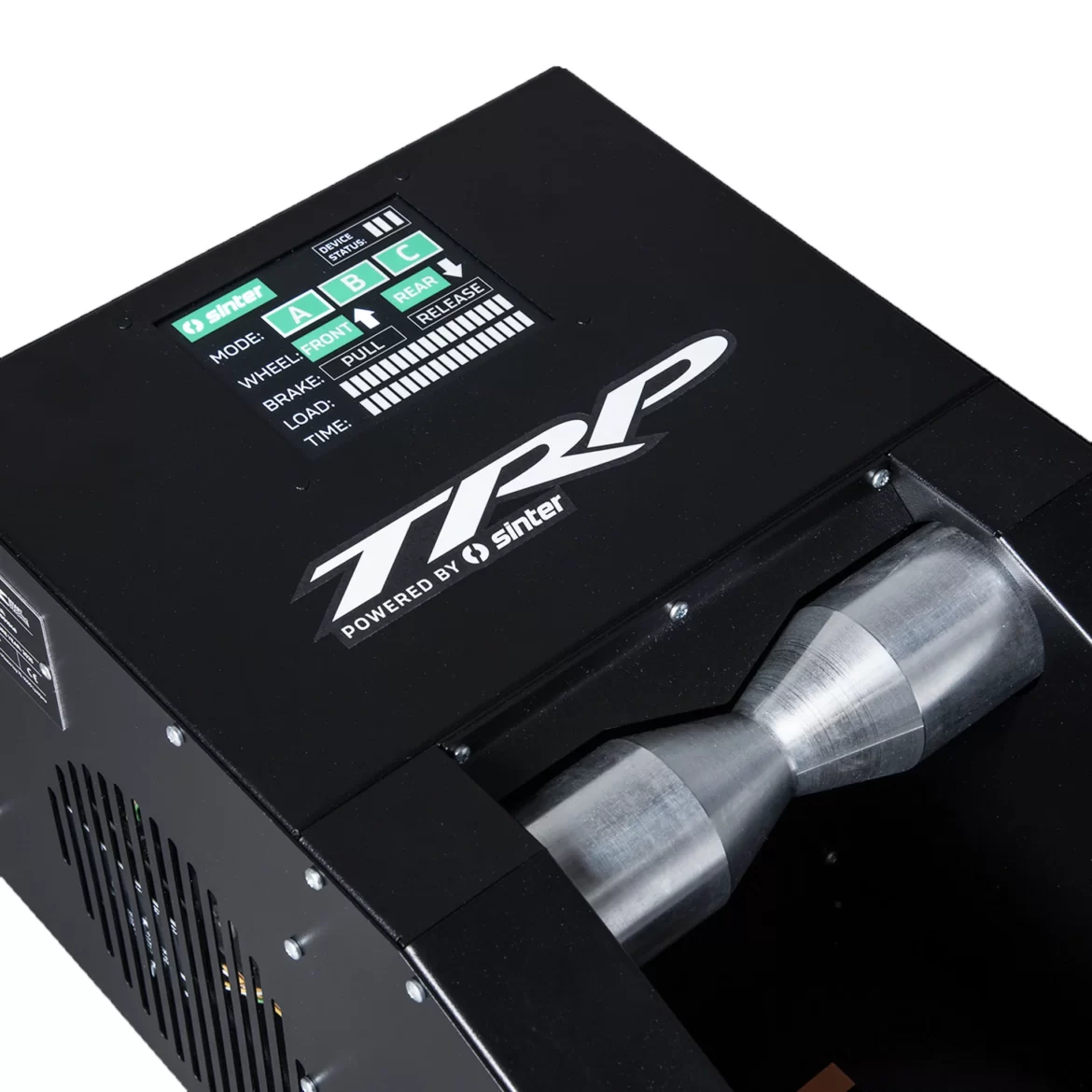A close-up view of a TRP device powered by Sinter, featuring a control panel with various buttons and a digital display indicating different operational modes. The front of the device shows a metallic component, and the overall design is sleek and industrial.
