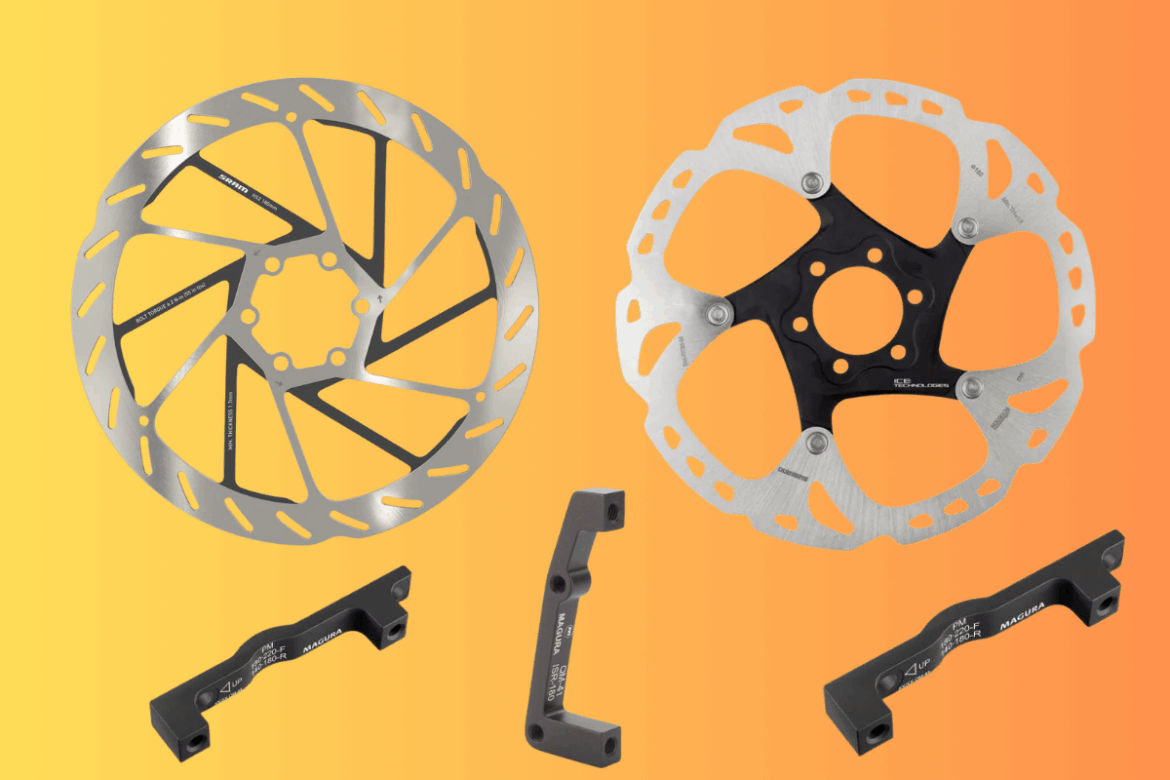 Two bicycle brake rotors are displayed against an orange gradient background. One rotor is silver with intricate cutouts for weight reduction, while the other has a black center and is also silver with distinctive cutouts. Below the rotors are two black mounting brackets labeled with "MAGURA" and specifications for proper installation.