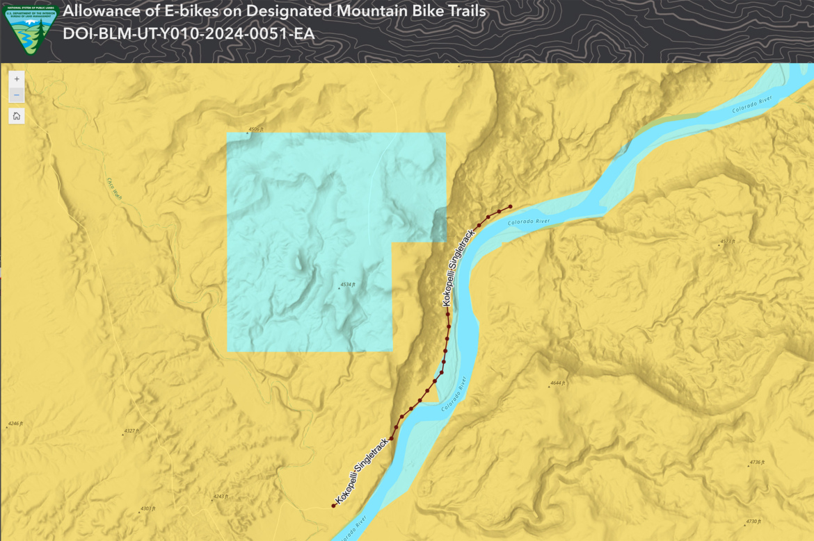 Map showing designated mountain bike trails, including areas where e-bikes are allowed, with elevations marked. The background is primarily yellow, representing terrain features, and a blue section highlights specific trail areas, including the Kokopelli Singletrack along the Colorado River.