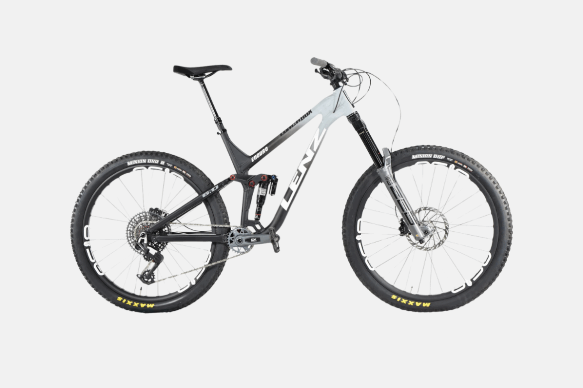 Alt text: A modern mountain bike featuring a sleek black and silver frame, wide tires with tread patterns, and a prominent suspension system, positioned against a plain background.