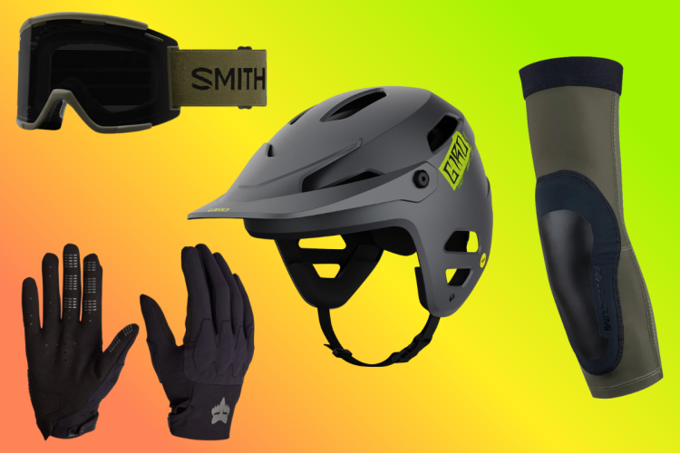 Image of cycling gear including a black helmet with a bright yellow logo, a pair of black gloves, a set of elbow pads, and goggles with a green strap, all displayed against a gradient background of yellow and orange.