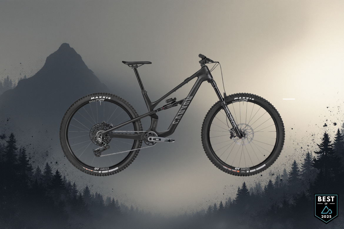 A sleek black mountain bike displayed against a misty landscape featuring dark silhouettes of trees and mountains in the background. The bike includes prominent branding, with high-performance tires and a modern frame design. A badge in the corner reads "Best of 2025."