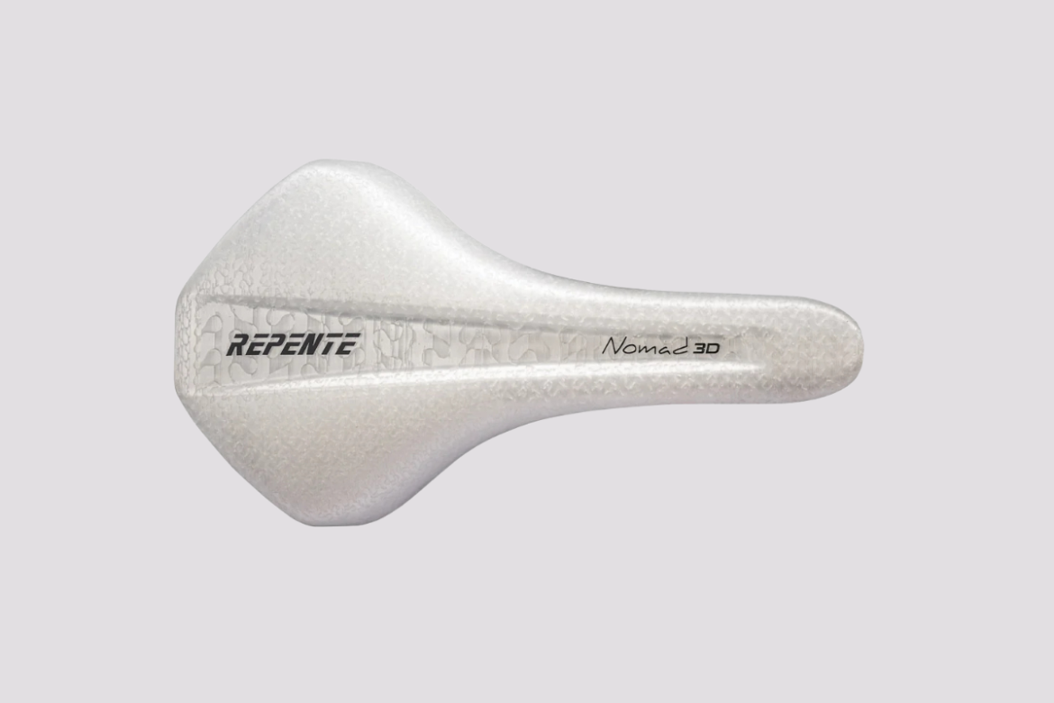 A white bicycle saddle with a sleek design featuring the brand name "REPENTE" and the model "Nomad 3D" printed on the side. The saddle has a smooth texture and a distinctive shape suitable for cycling.