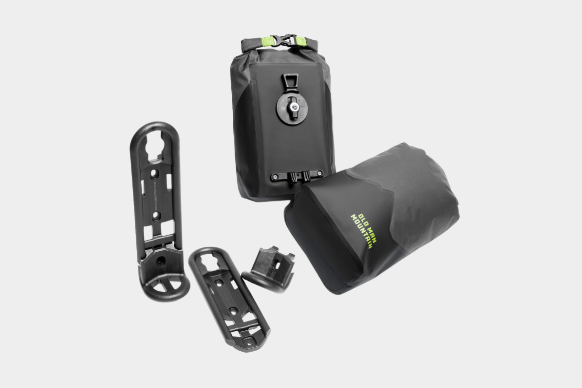 A collection of outdoor gear including a waterproof bag with a roll-top closure and two mounting attachments in black plastic, showcasing durability and functionality for outdoor activities.