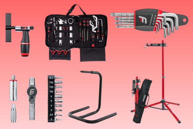 A variety of bicycle repair tools and a work stand arranged against a gradient background. Tools include wrenches, hex keys, a ratchet tool, and a tool bag. The work stand is in red and black, showcasing durability and portability for bike maintenance.