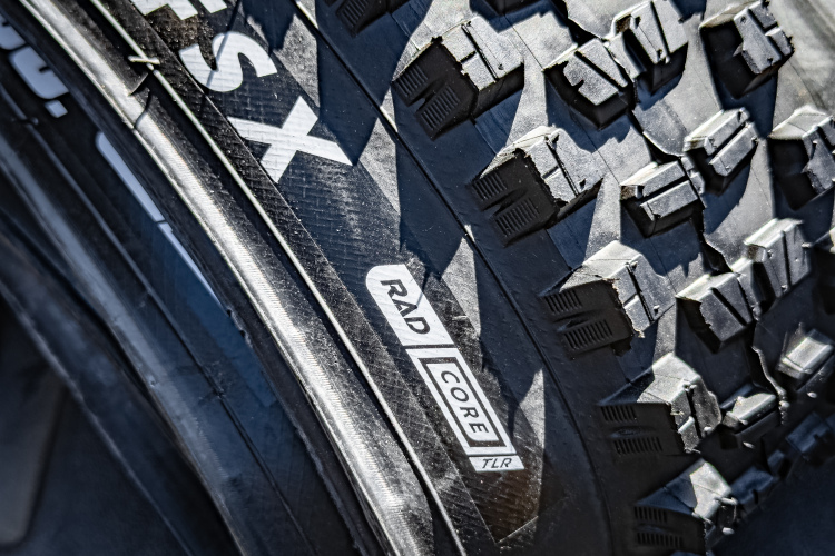 Close-up image of a rugged bicycle tire showing the tread pattern and branding, including "FSX" and "RAD CORE TLR."